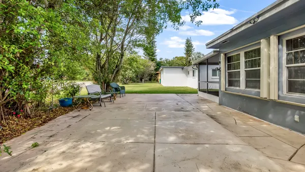 a view of a backyard with table and chairs and potted plants