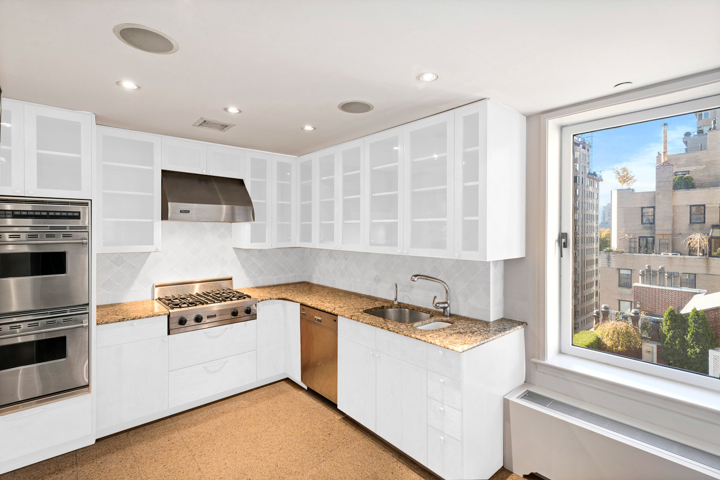 15 East 69th Street, Unit 10D Manhattan, NY 10021 - Photo 4 of 12 a kitchen with a sink a stove and cabinets