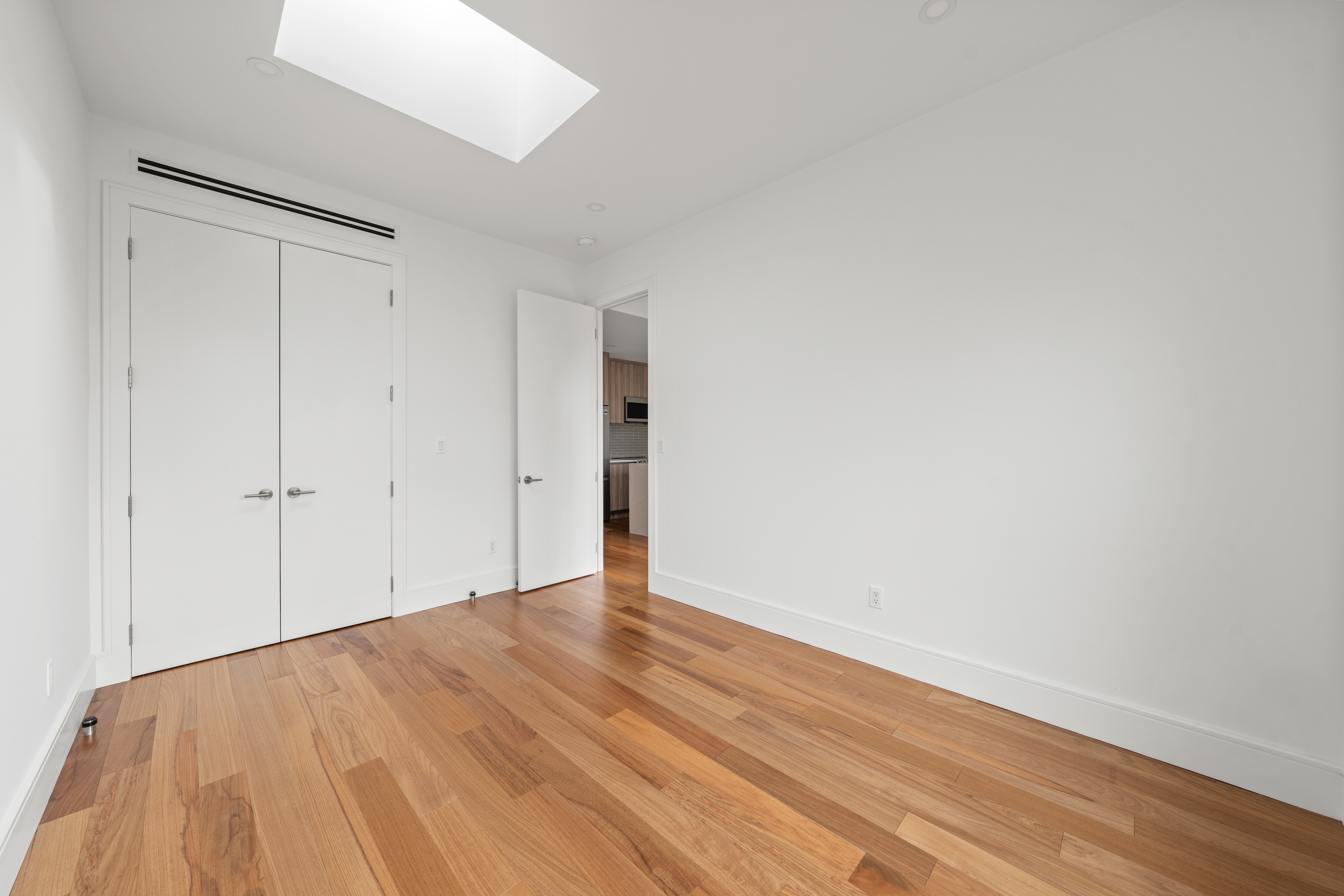 82 Cooper Street, Unit 3A Brooklyn, NY 11207 - Photo 4 of 17 a view of an empty room with wooden floor