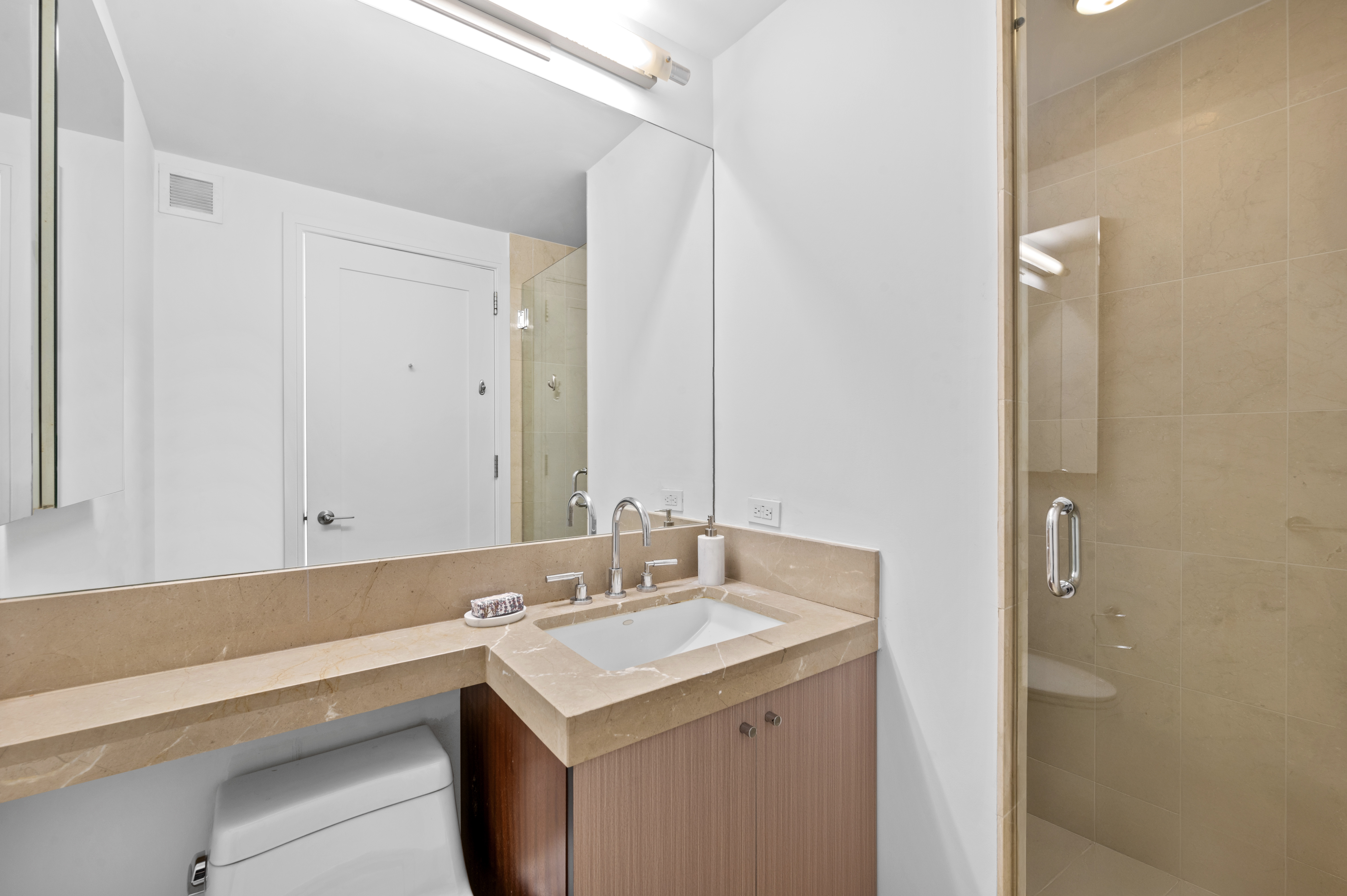 30 West Street, Unit 25G Manhattan, NY 10004 - Photo 11 of 17 a bathroom with a sink and a mirror