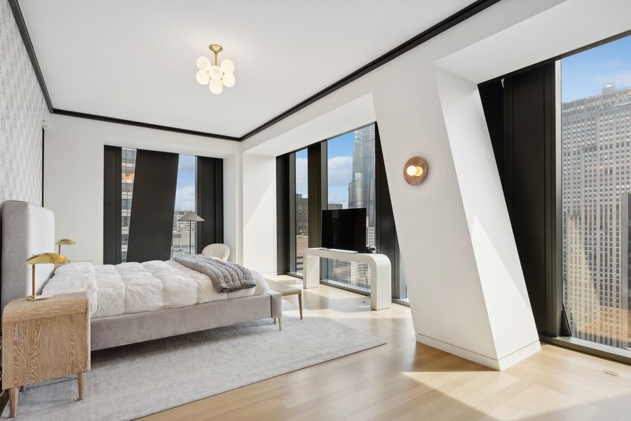 53 West 53rd Street, Unit 52B Manhattan, NY 10019 - Photo 1 of 15 a bedroom with a bed and a large mirror