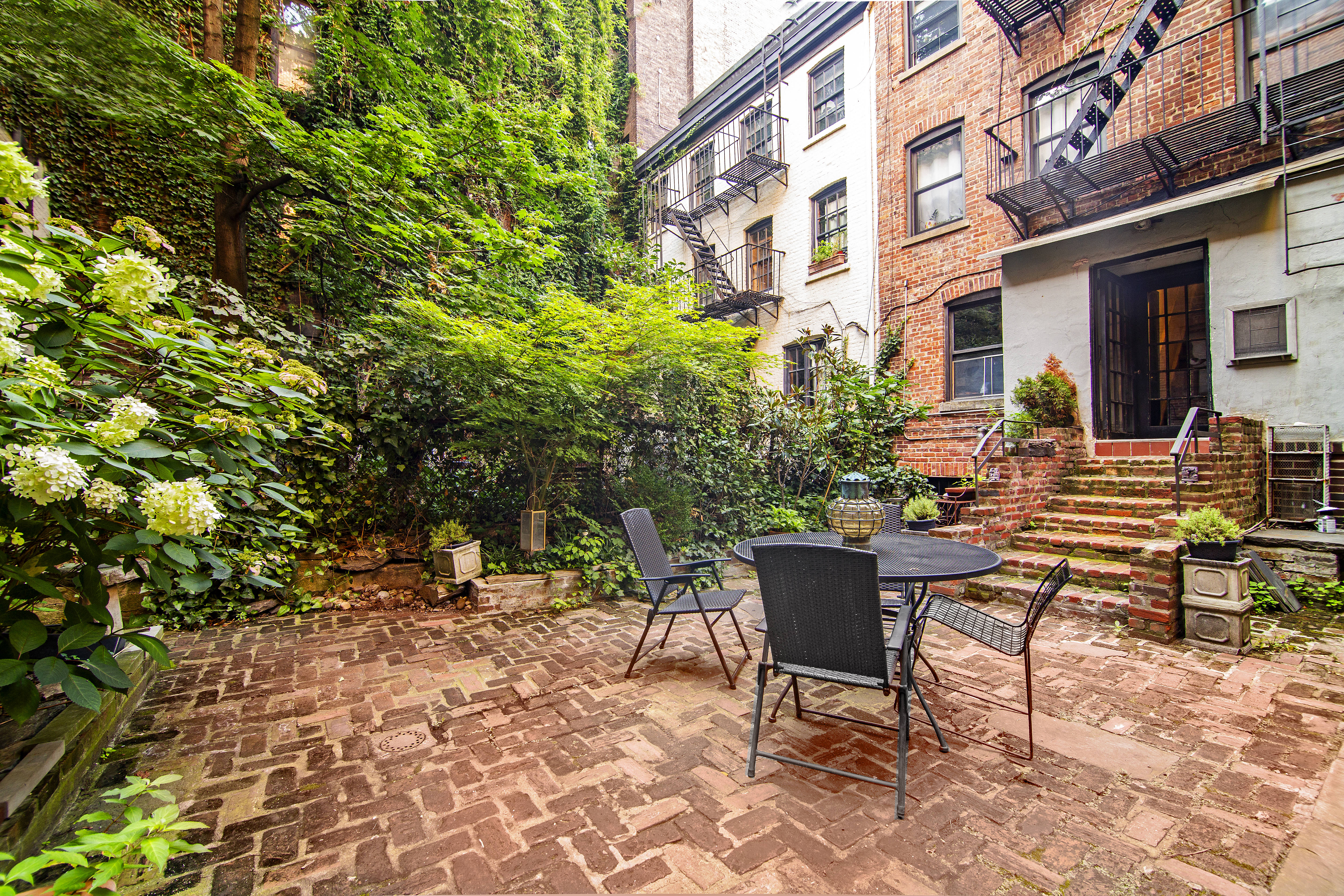 113 1/2 West 15th Street, Unit 1W Manhattan, NY 10011 - Photo 8 of 12 a view of a patio with a table and chairs and potted plants
