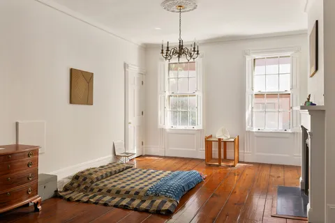 a bedroom with a bed and wooden floor