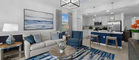 a living room with furniture a table and kitchen view