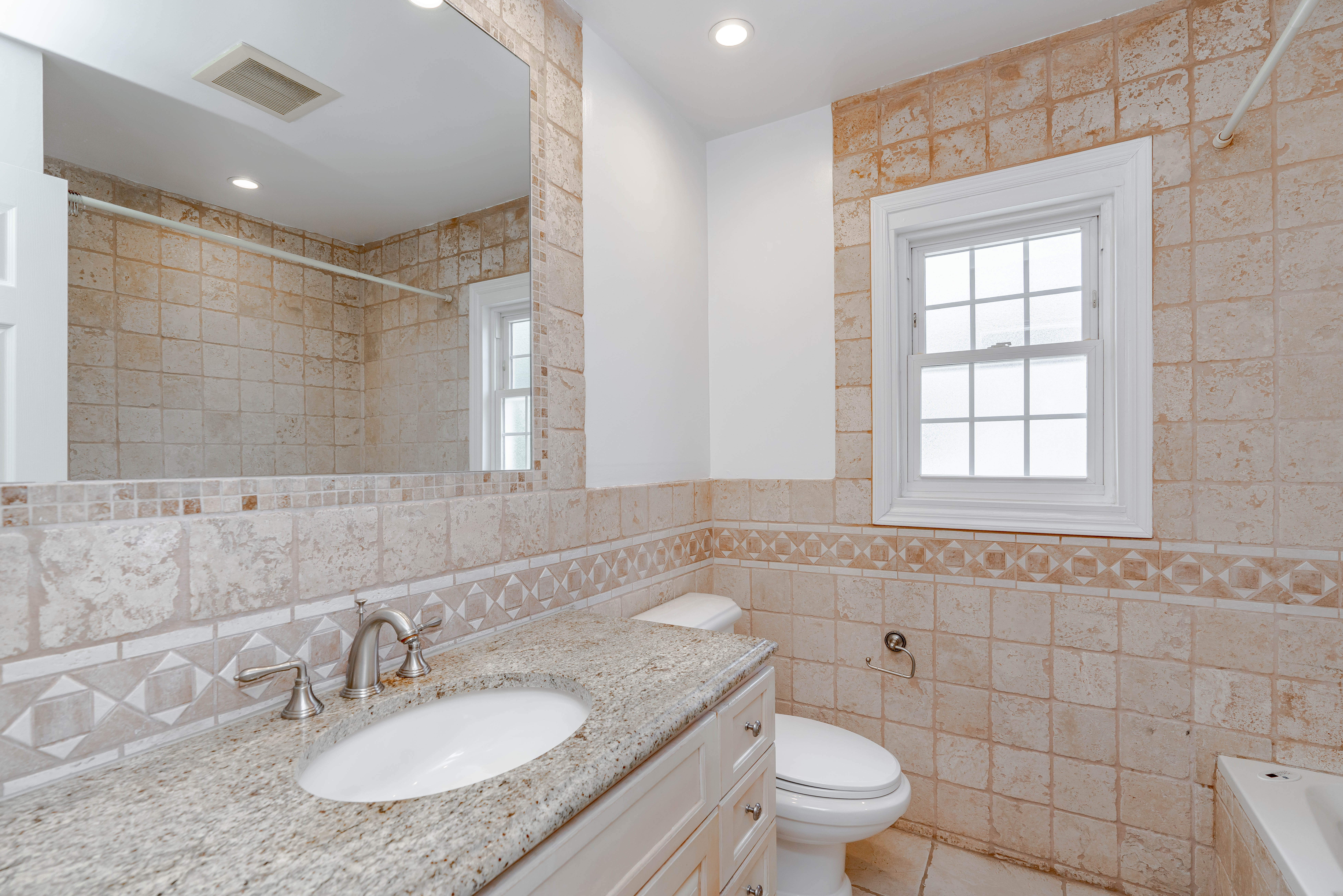 15-80 209th Street, Unit 2 Queens, NY 11360 - Photo 7 of 11 a bathroom with a granite countertop sink a toilet and a mirror