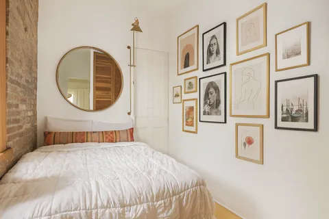 a bedroom with a bed and a painting on the wall