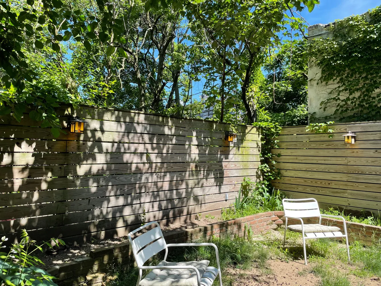 a view of a patio with table and chairs potted plants and a bench