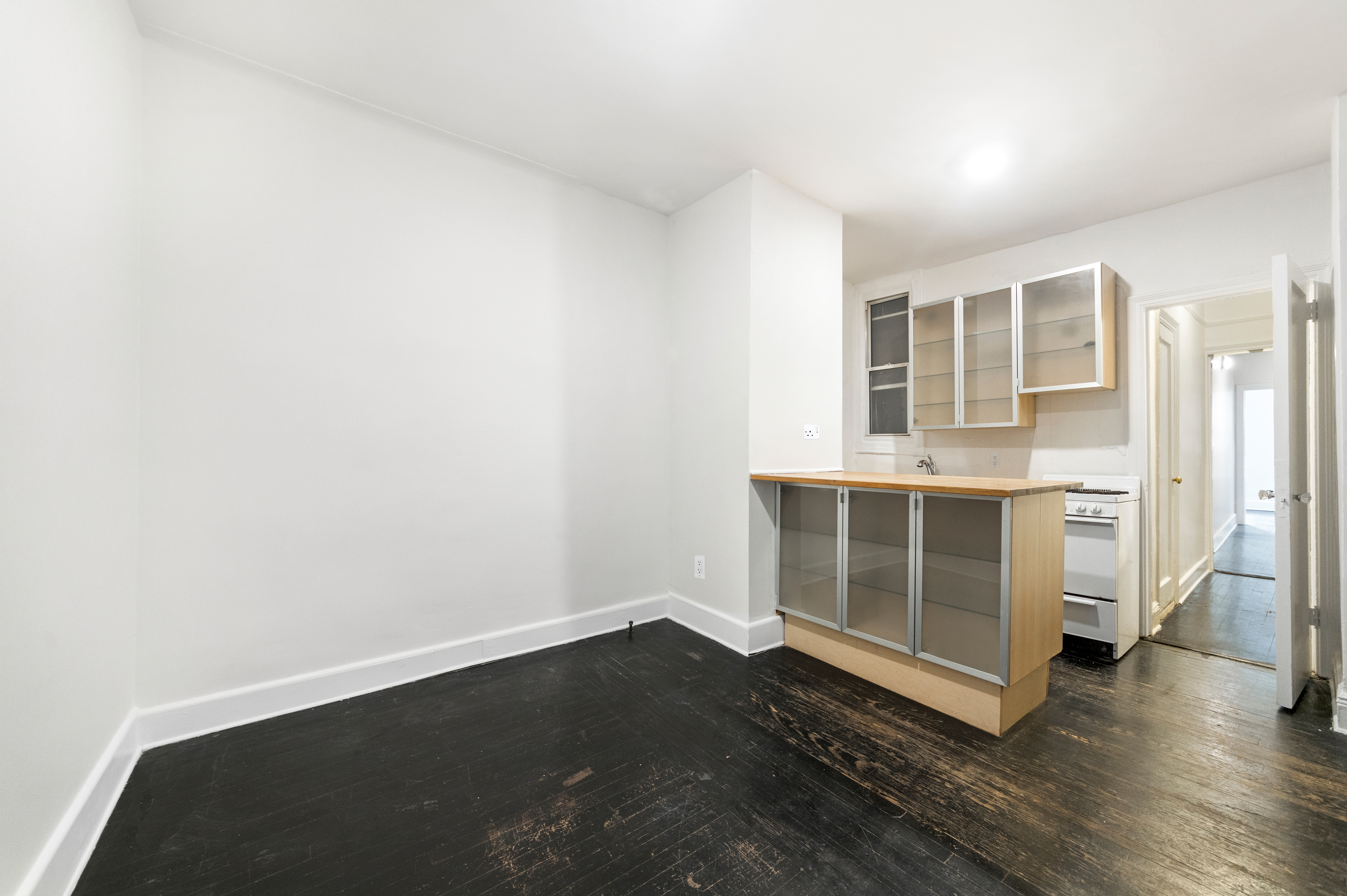 1605 York Avenue, Unit 1A Manhattan, NY 10028 - Photo 3 of 8 an empty room with wooden floor and windows