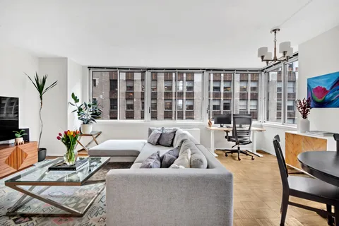 a living room with furniture and a floor to ceiling window