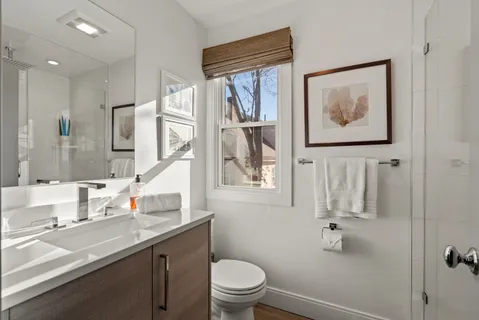 a bathroom with a sink a toilet and a window