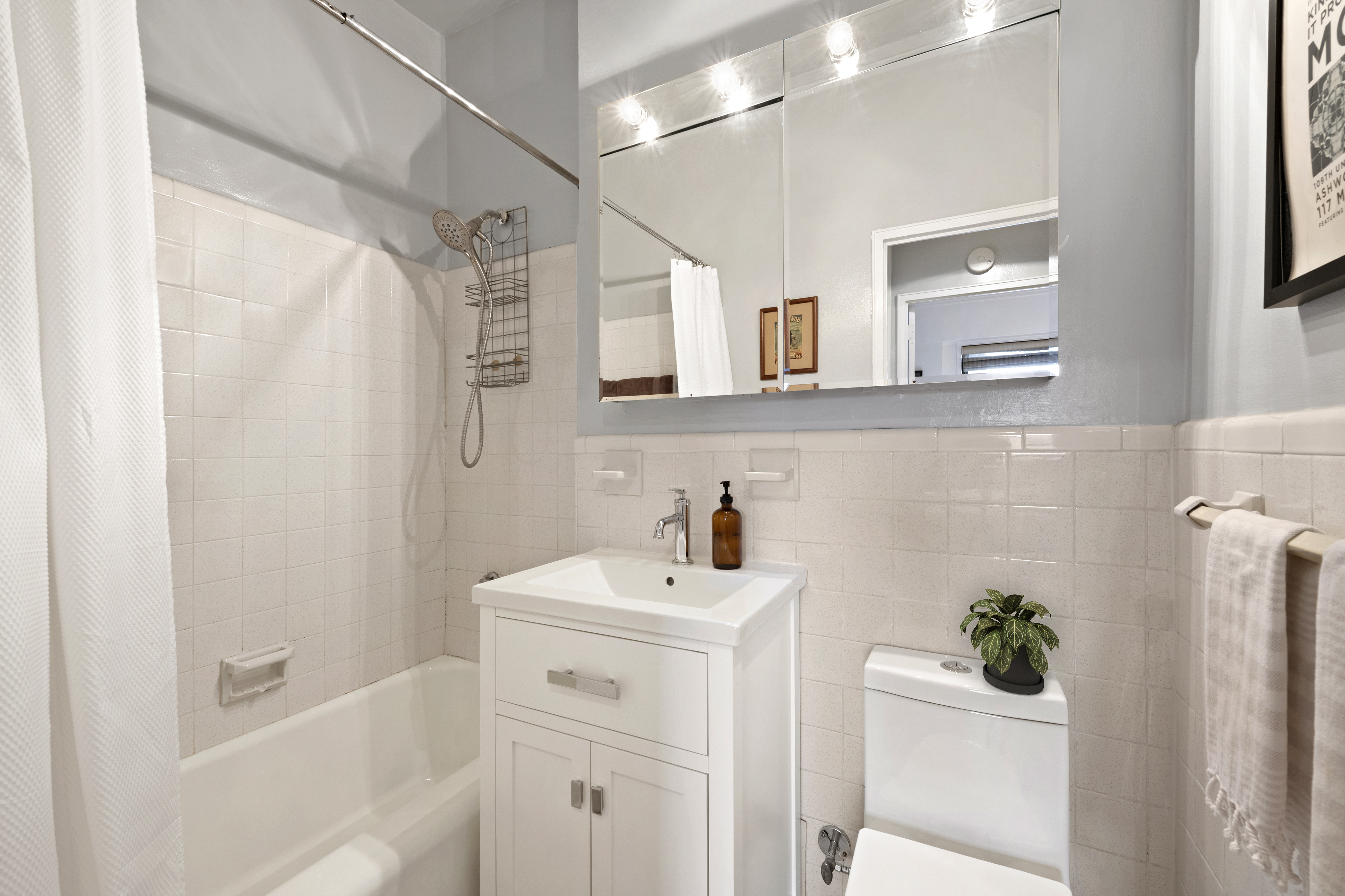 201 East 21st Street, Unit 12M Manhattan, NY 10010 - Photo 7 of 10 a bathroom with a sink a window and shower