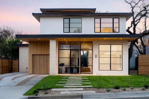 a front view of a house with a yard and potted plants