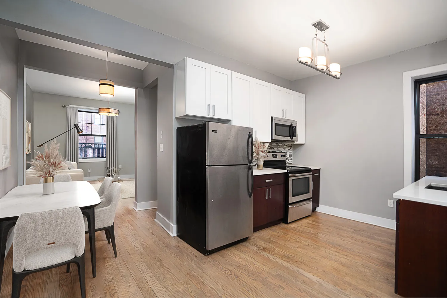 a kitchen with stainless steel appliances granite countertop a refrigerator a stove a sink dishwasher a dining table and chairs with wooden floor