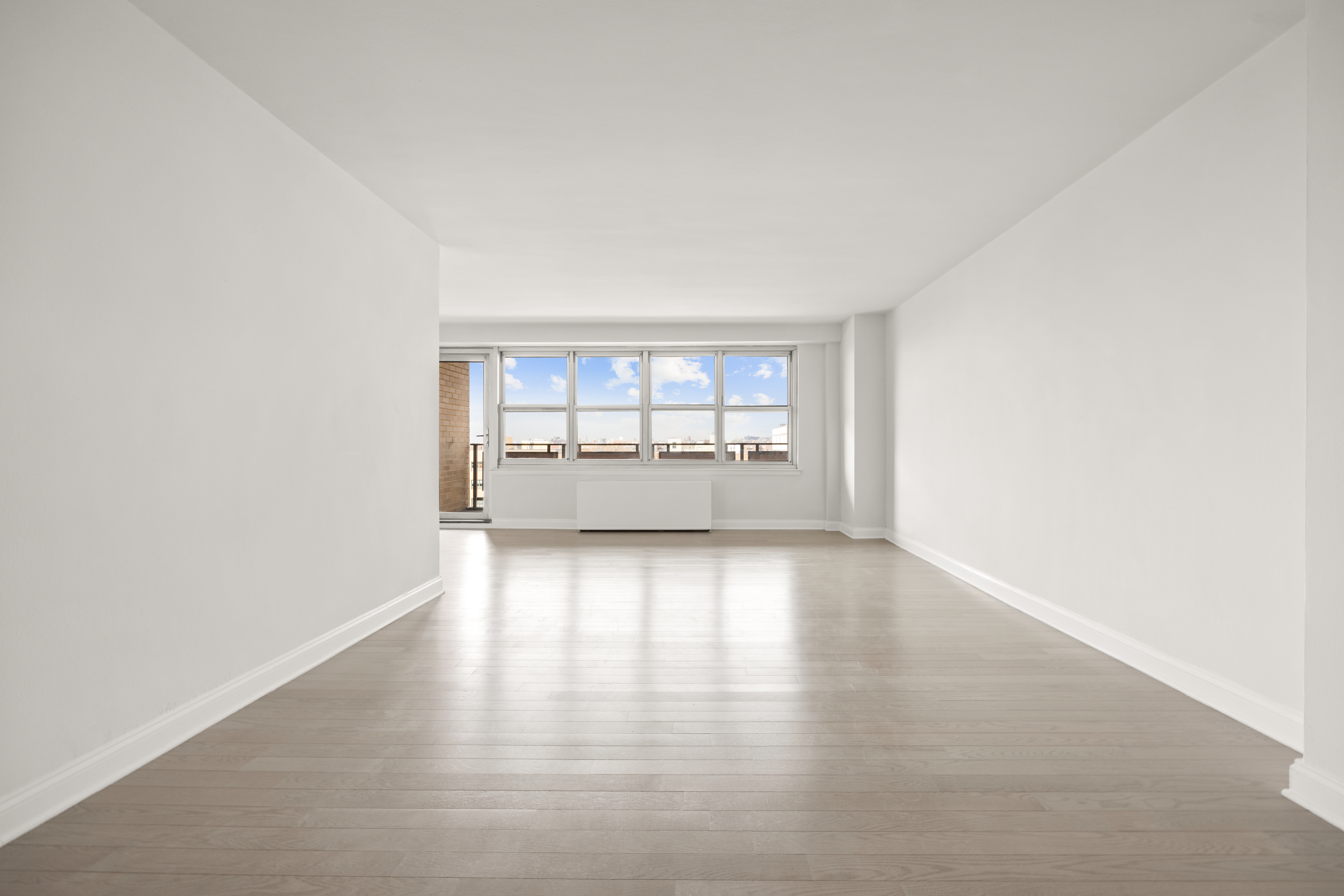 135 Ocean Parkway, Unit 9M Brooklyn, NY 11218 - Photo 14 of 18 an empty room with wooden floor and windows