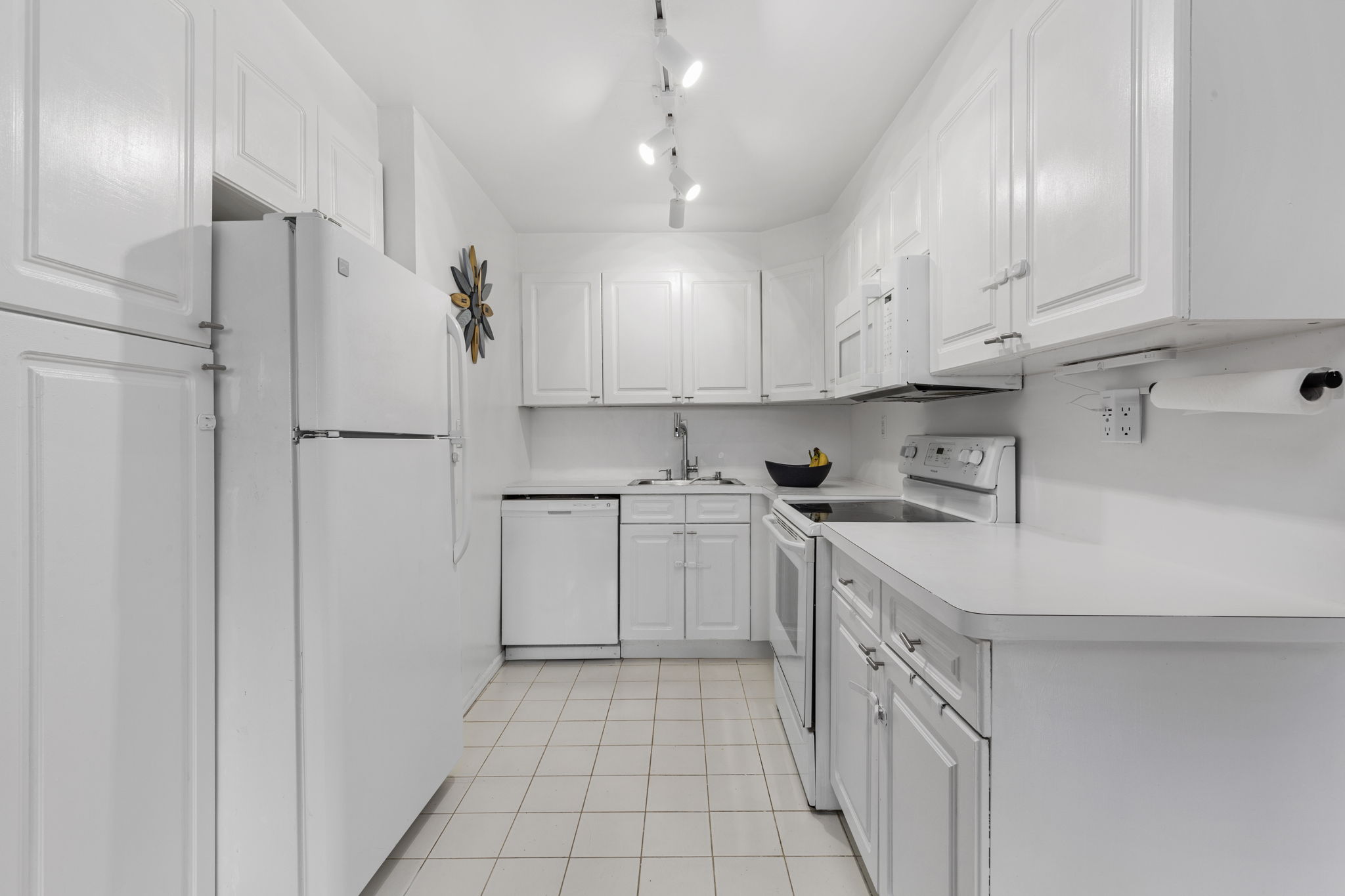 11-01 162nd Street, Unit 3D Queens, NY 11357 - Photo 4 of 16 a kitchen with white cabinets and white appliances