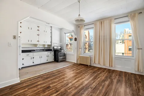 a large kitchen with stainless steel appliances granite countertop a lot of counter space and wooden floors