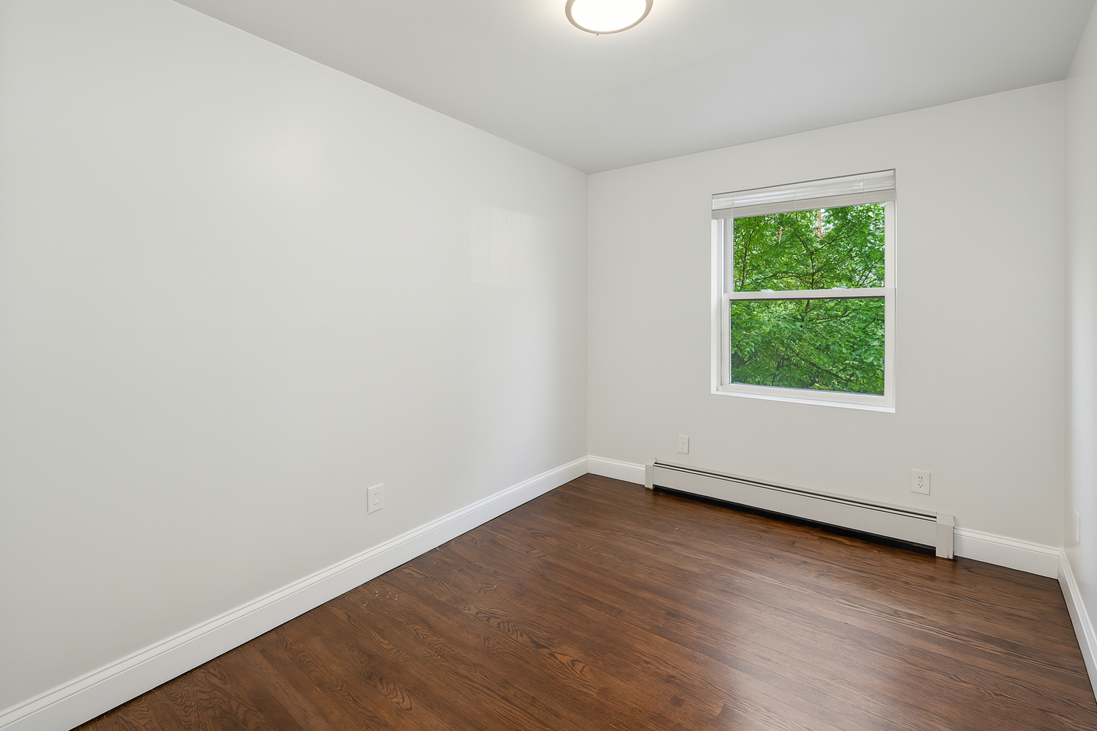 189 Woodpoint Road Brooklyn, NY 11211 - Photo 11 of 21 an empty room with wooden floor and windows