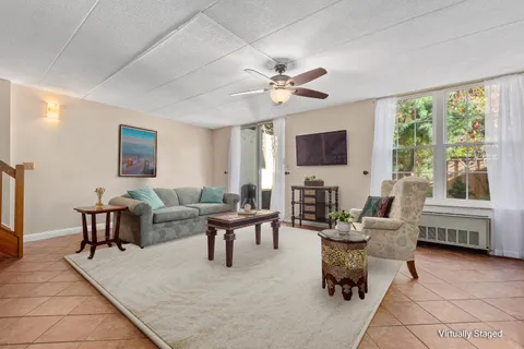 a living room with furniture a flat screen tv and a large window