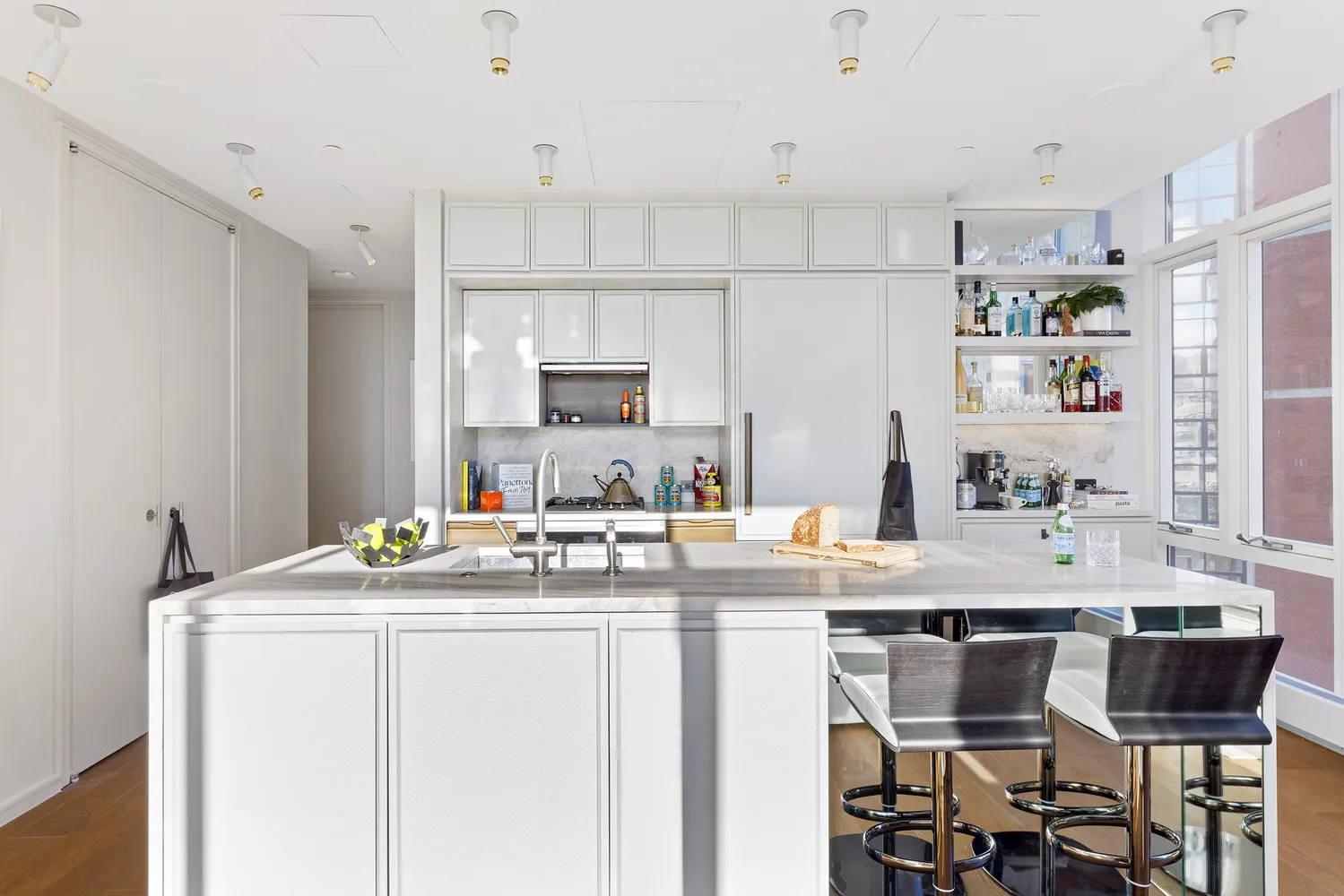 a room with stainless steel appliances kitchen island granite countertop a sink a stove and white cabinets