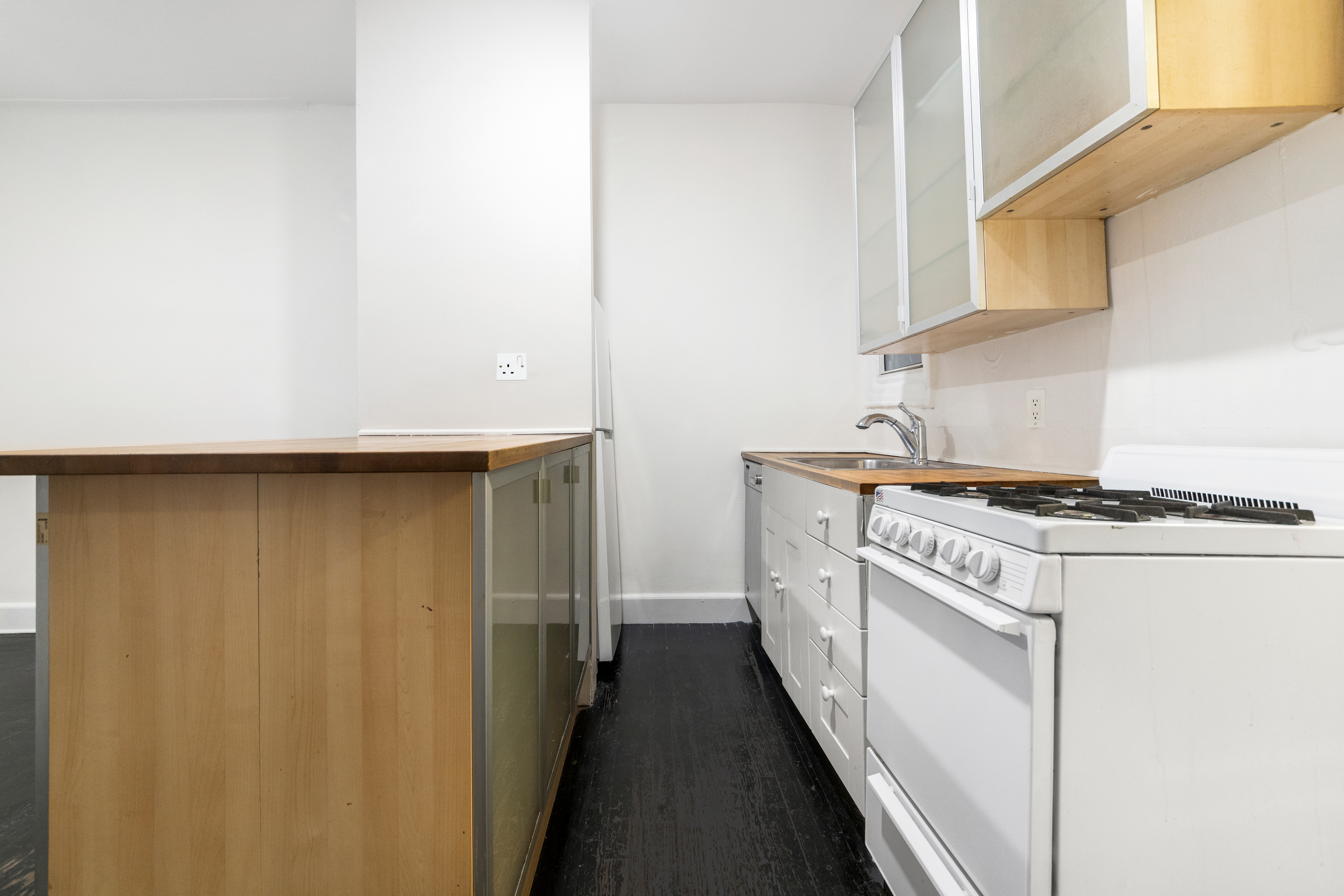 1605 York Avenue, Unit 2A Manhattan, NY 10028 - Photo 2 of 8 a kitchen with cabinets and a stove