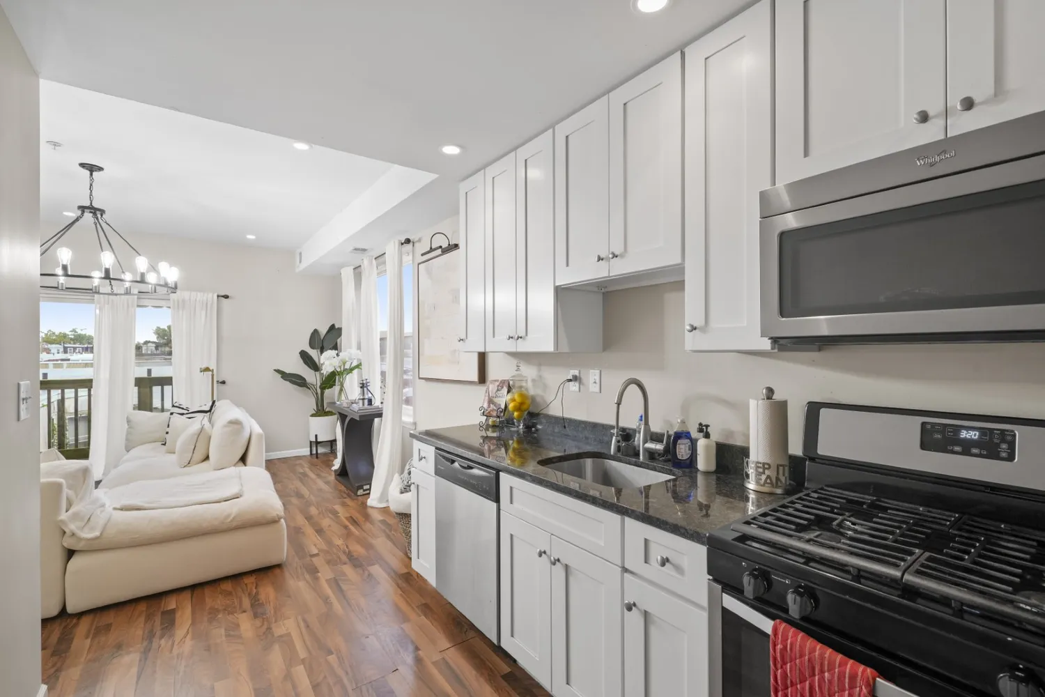 a kitchen with granite countertop a refrigerator stove top oven and sink