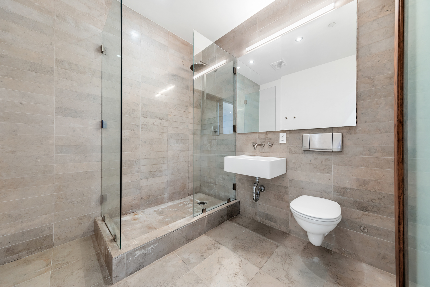 808 Broadway, Unit 4K Manhattan, NY 10003 - Photo 5 of 7 a bathroom with a shower sink mirror and toilet