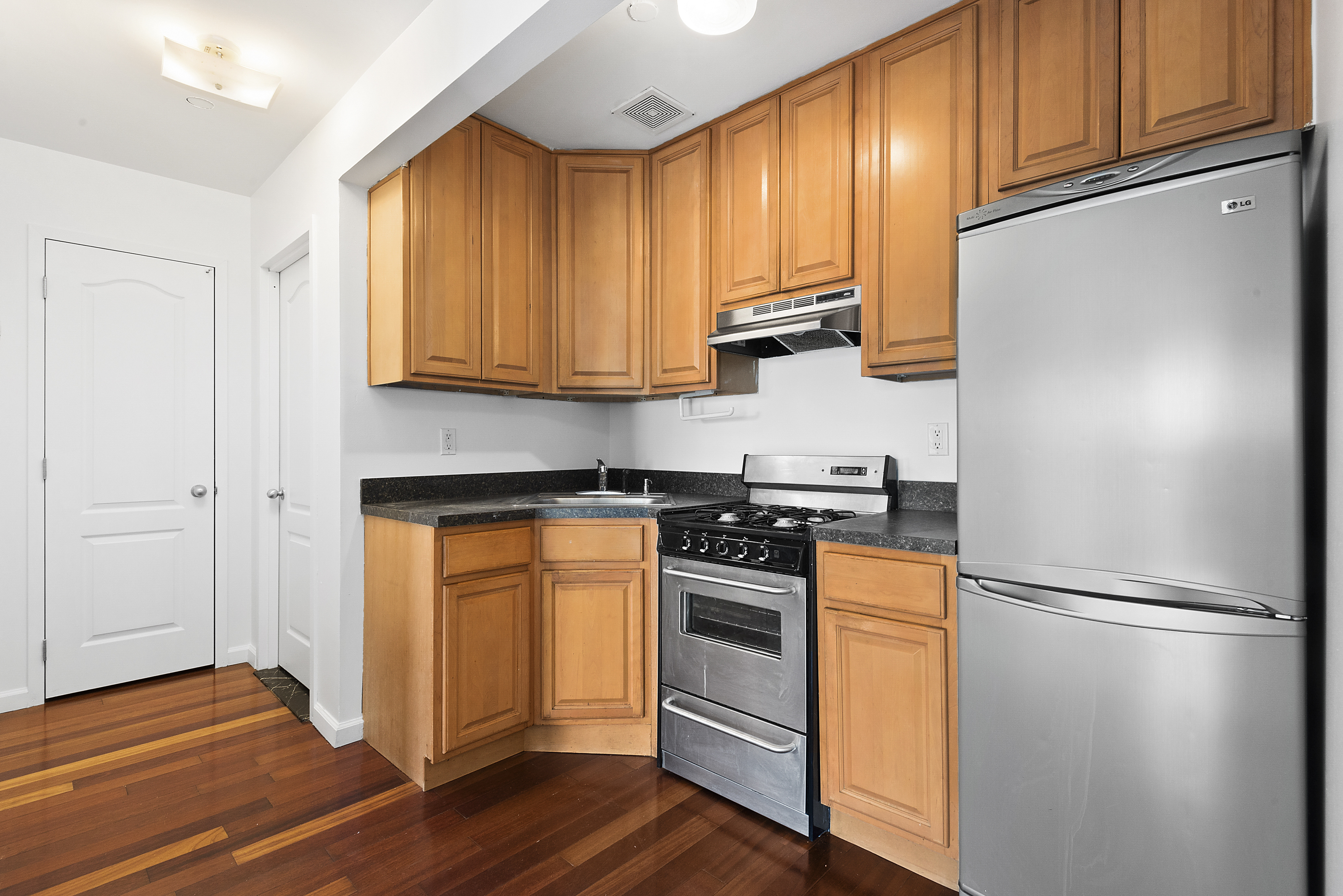 122 Boerum Street, Unit 4R Brooklyn, NY 11206 - Photo 3 of 9 a kitchen with stainless steel appliances granite countertop a refrigerator stove and sink