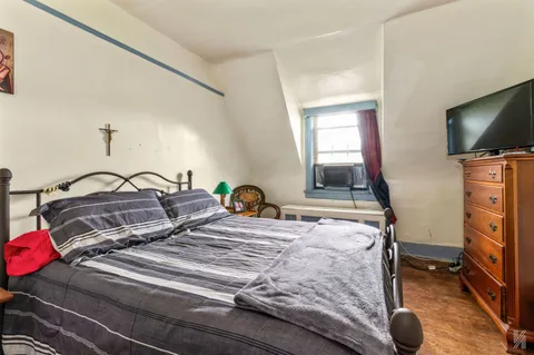 a bedroom with a bed and a flat screen tv