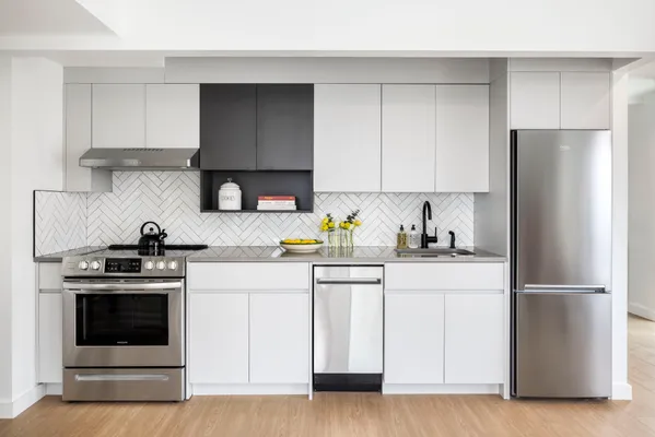 a kitchen with cabinets appliances and a wooden floor