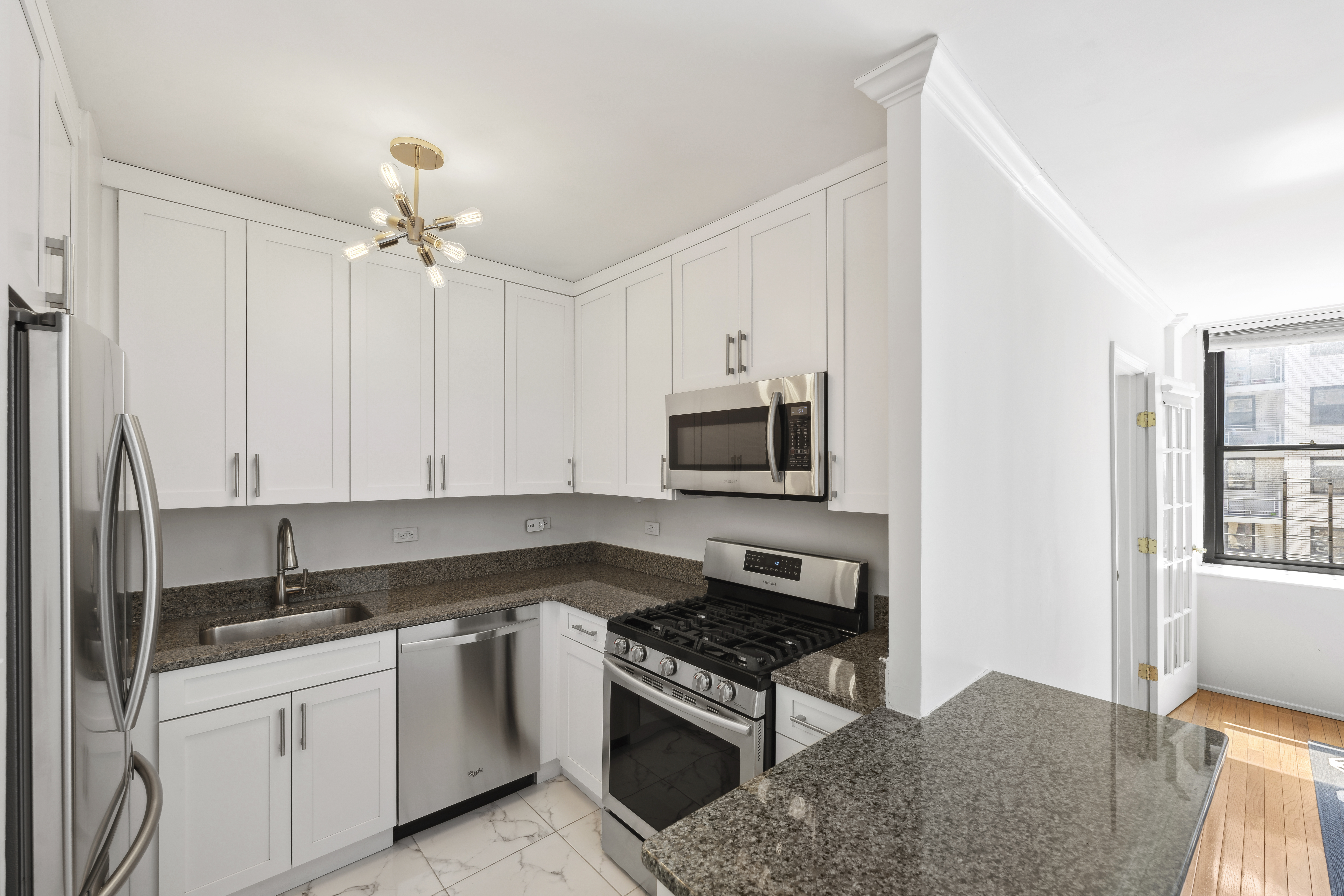 301 East 87th Street, Unit 16E Manhattan, NY 10128 - Photo 6 of 16 a kitchen with stainless steel appliances granite countertop a stove a sink and a refrigerator