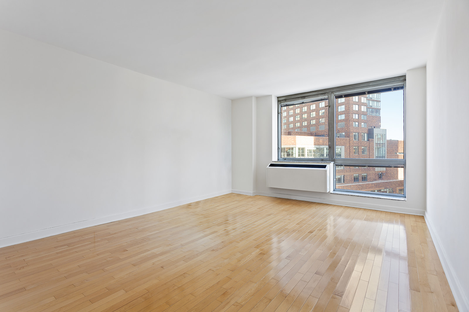 1965 Broadway, Unit 11D Manhattan, NY 10023 - Photo 6 of 13 a view of an empty room with a window and wooden floor
