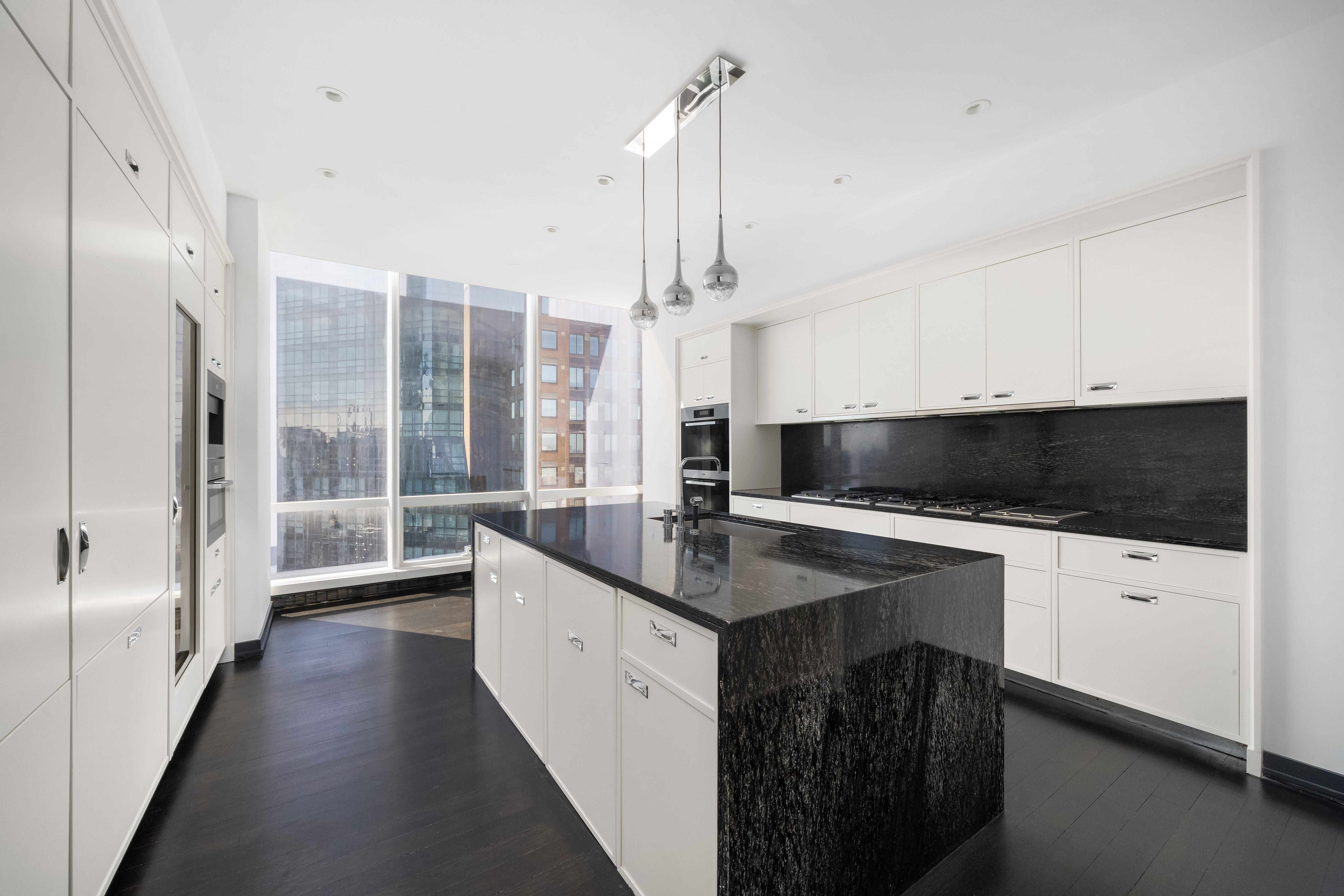 157 West 57th Street, Unit 56C Manhattan, NY 10019 - Photo 4 of 10 a kitchen with a sink and a refrigerator
