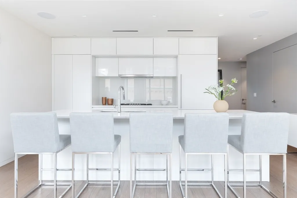 a kitchen with a table chairs and white cabinets