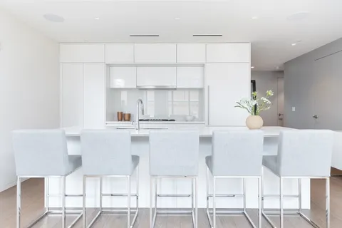 a kitchen with a table chairs and white cabinets