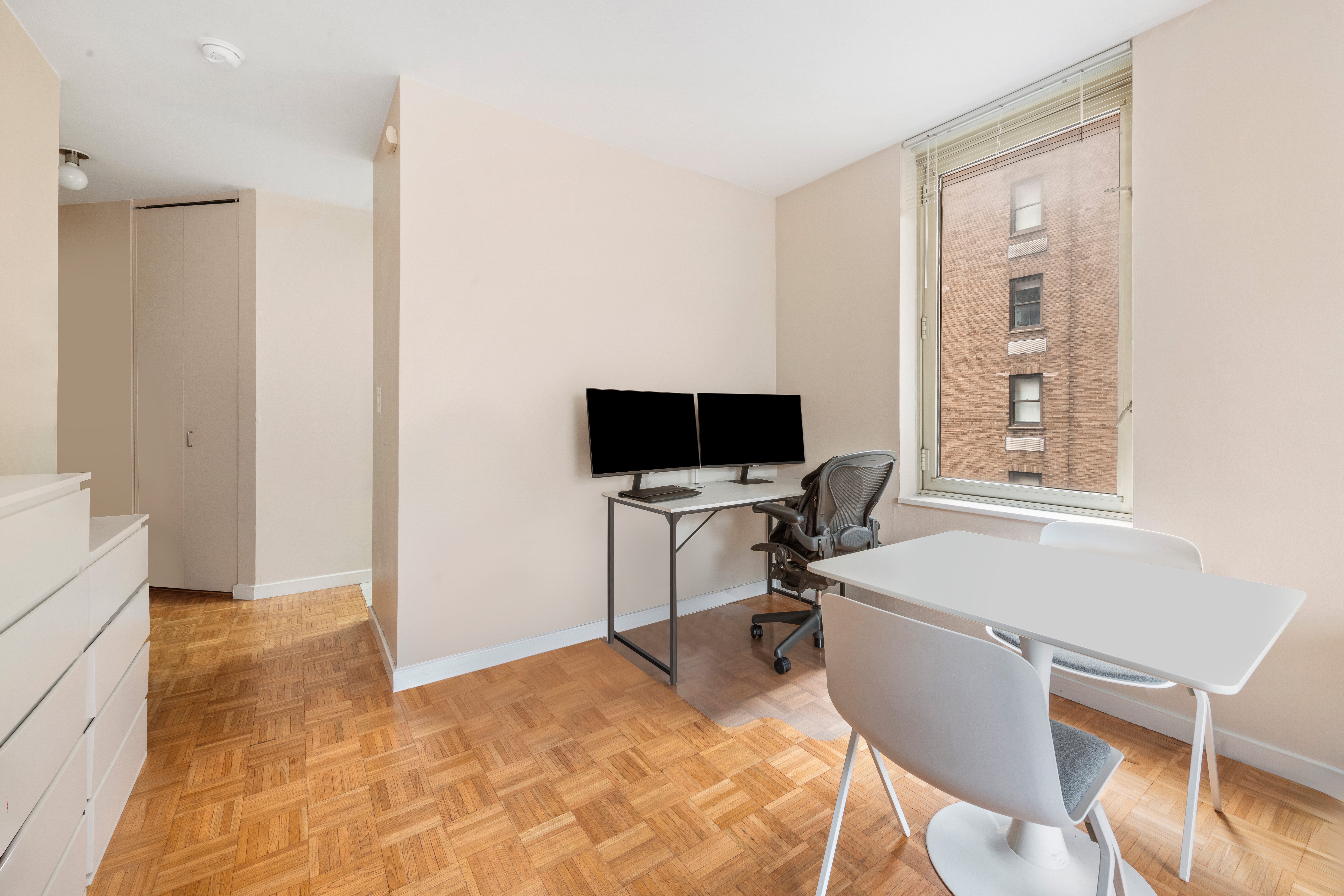 145 East 48th Street, Unit 12B Manhattan, NY 10017 - Photo 3 of 7 a view of a workspace with furniture and a window