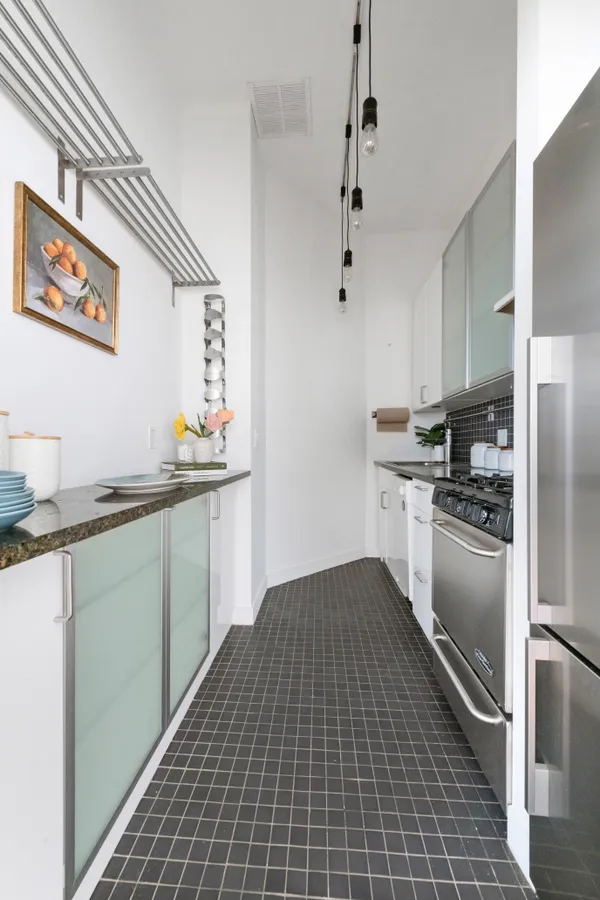 a kitchen with granite countertop a refrigerator and a sink
