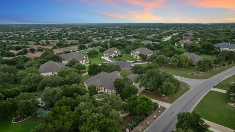 an aerial view of residential houses with outdoor space and trees