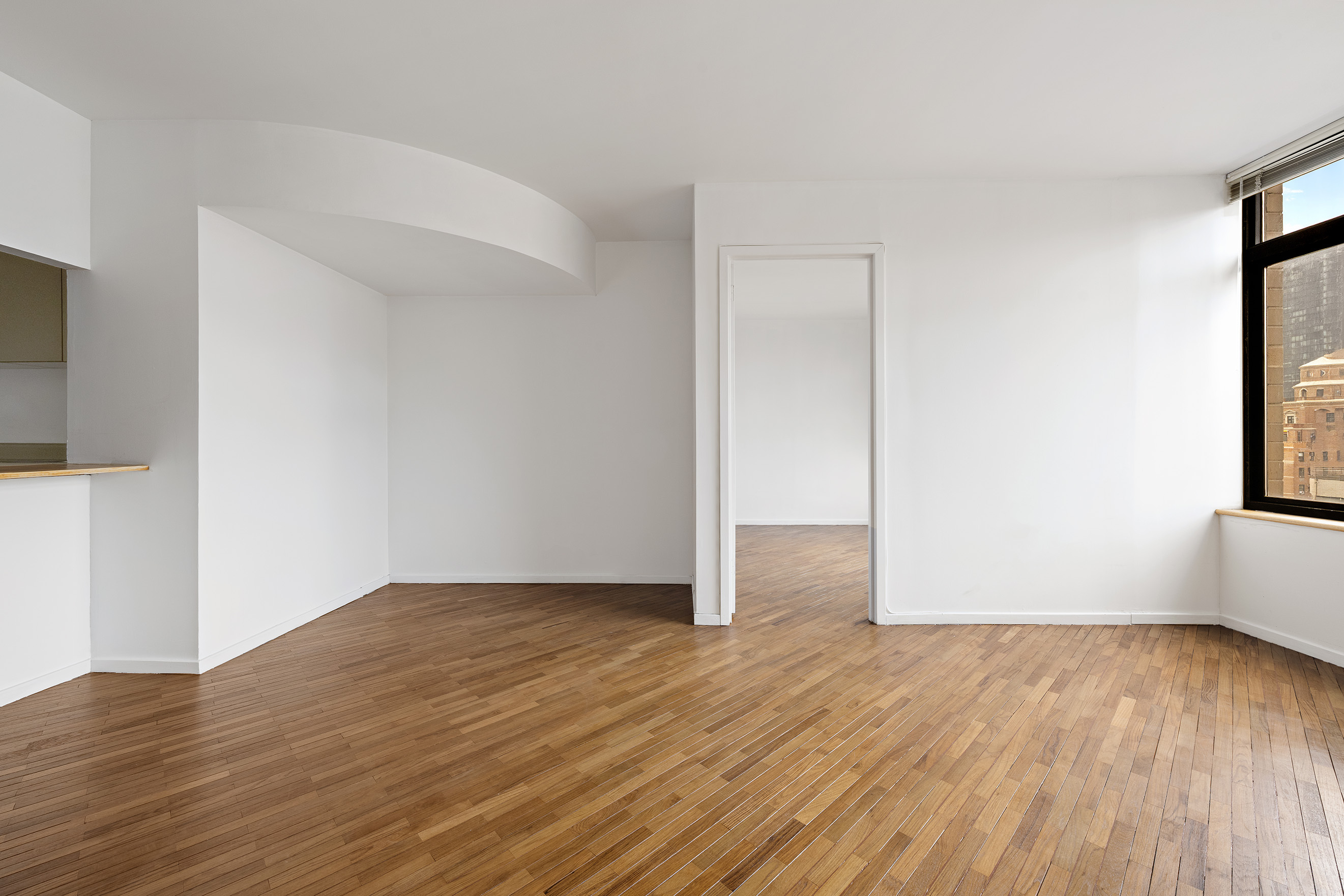 400 East 70th Street, Unit 1903 Manhattan, NY 10021 - Photo 2 of 6 an empty room with wooden floor and windows