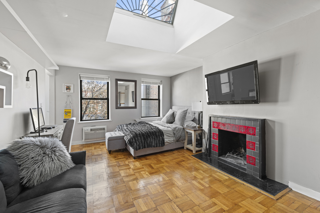 87 St Marks Place, Unit 4E Manhattan, NY 10009 - Photo 1 of 9 a living room with furniture and a fireplace