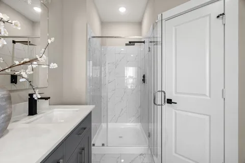 a bathroom with a shower sink and mirror