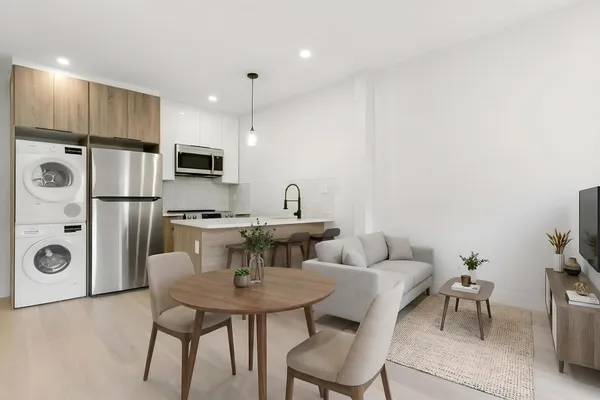a kitchen with stainless steel appliances a table chairs and a refrigerator
