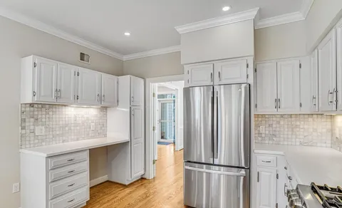 a kitchen with granite countertop a refrigerator sink and cabinets