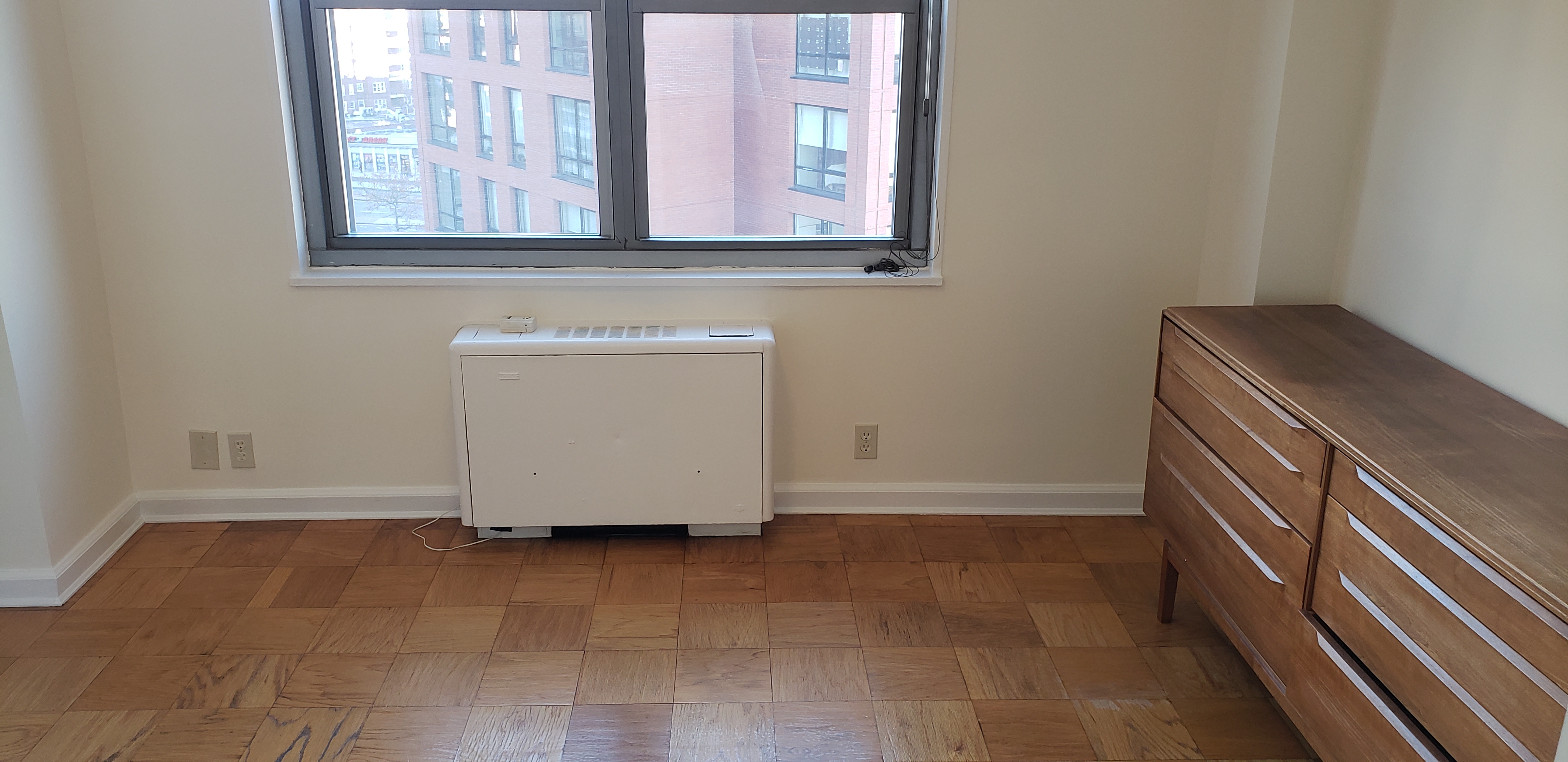 70-25 Yellowstone Boulevard, Unit 11D Queens, NY 11375 - Photo 12 of 25 a view of an empty room with wooden floor and a window