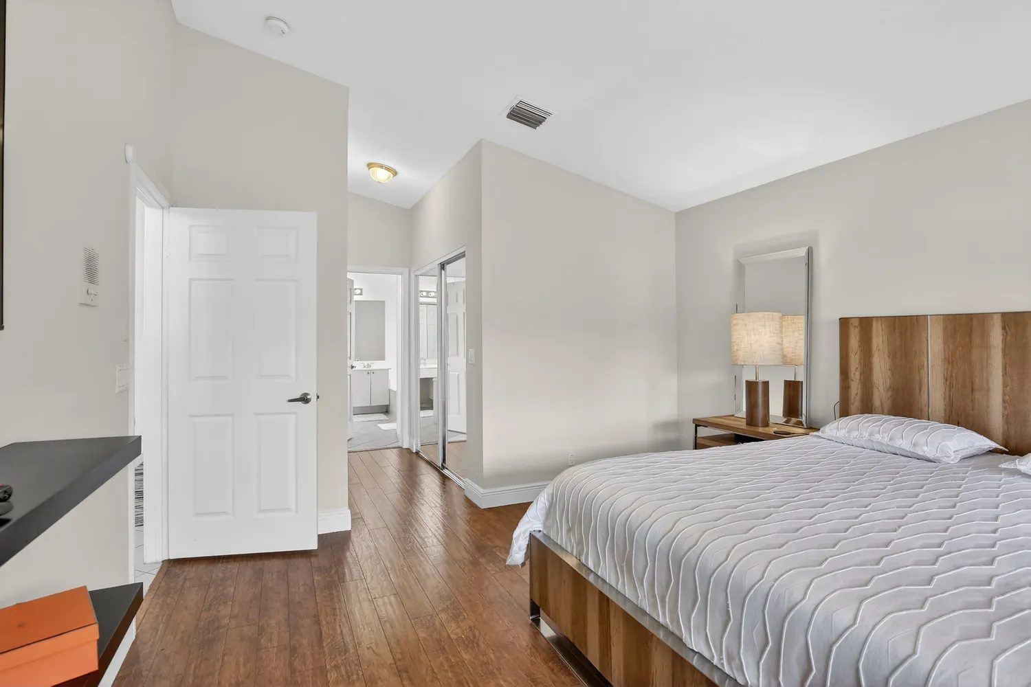 a bedroom with a bed and wooden floor