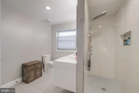 a bathroom with a sink a toilet and shower