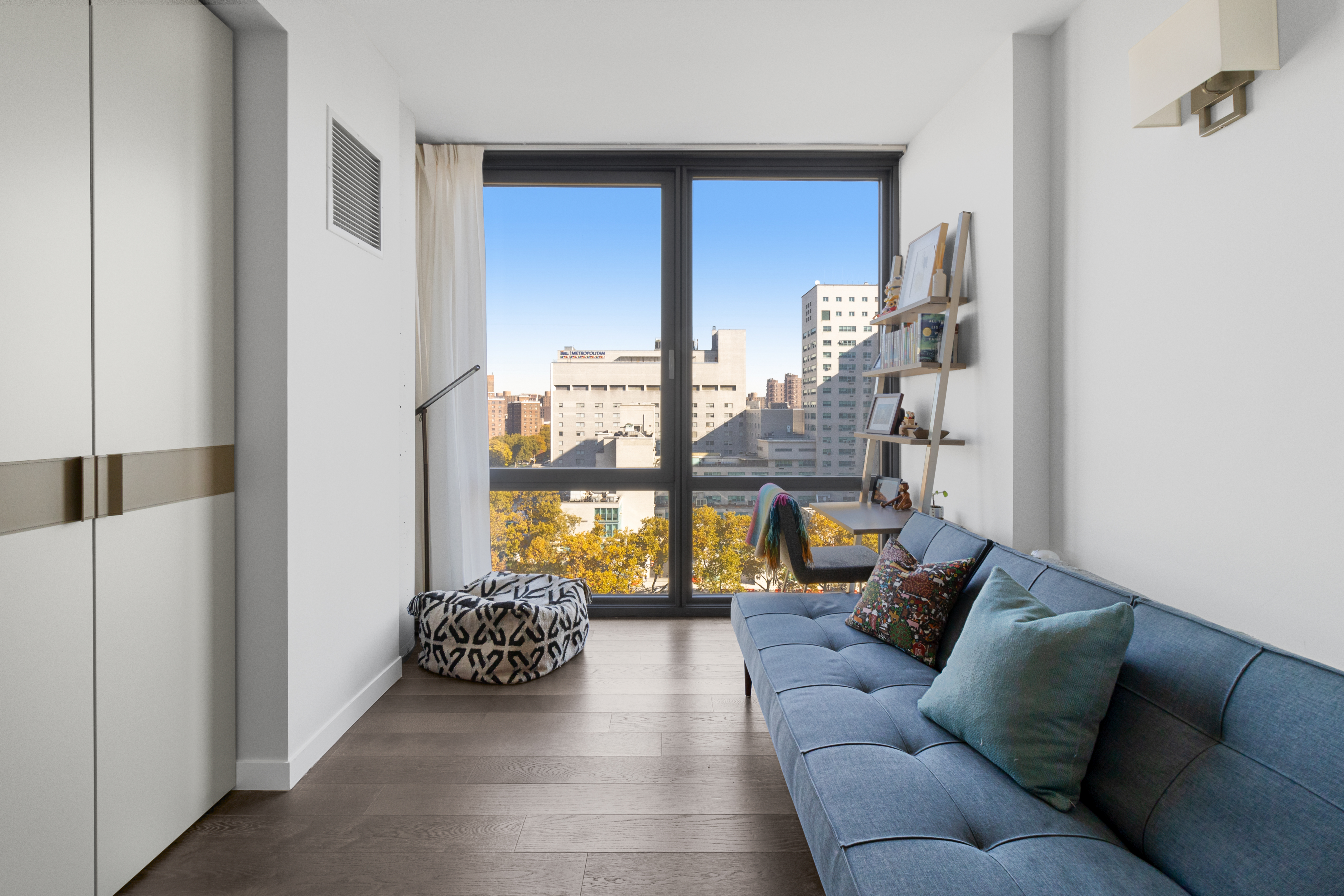 302 East 96th Street, Unit 1103 Manhattan, NY 10128 - Photo 13 of 22 a living room with furniture and a floor to ceiling window