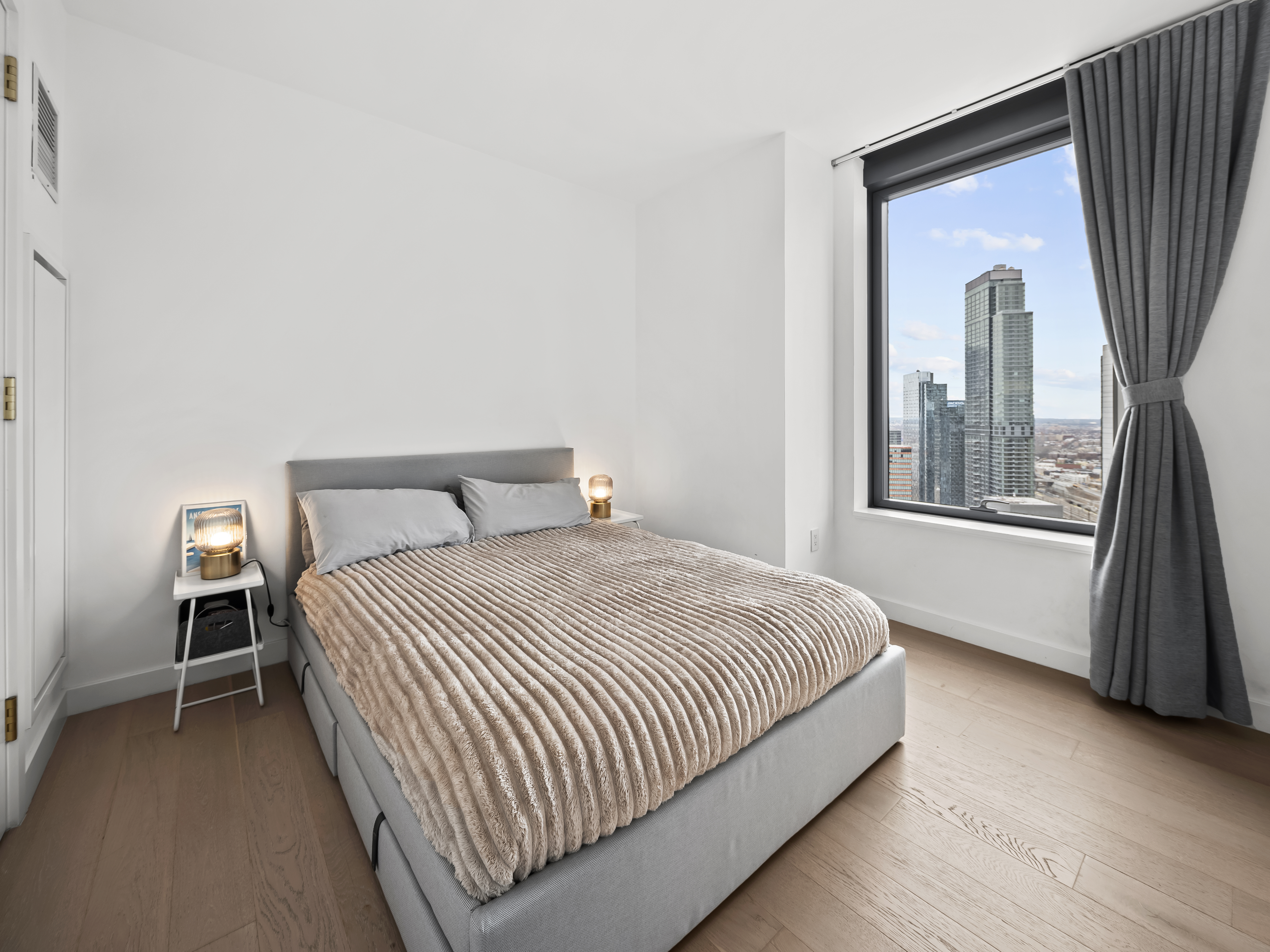 45-3 Court Square, Unit 4406 Queens, NY 11101 - Photo 7 of 22 a bedroom with a bed next to a window
