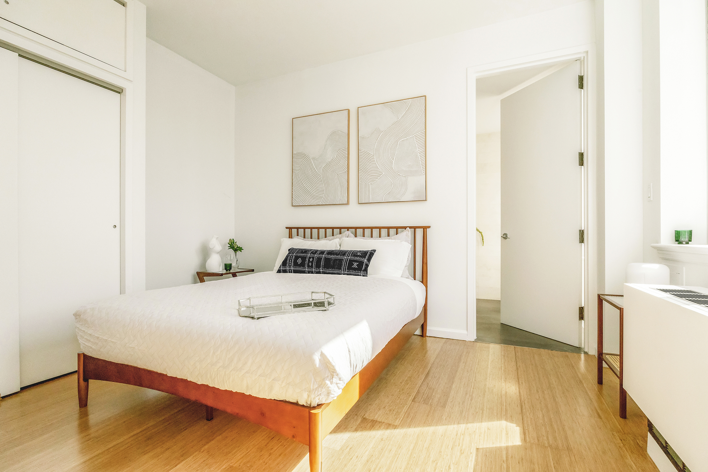 26 Broadway, Unit 704 Brooklyn, NY 11249 - Photo 8 of 20 a bedroom with a bed and a table in it