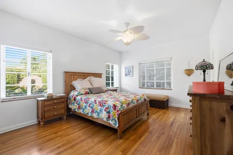 a bedroom with a bed and wooden floor