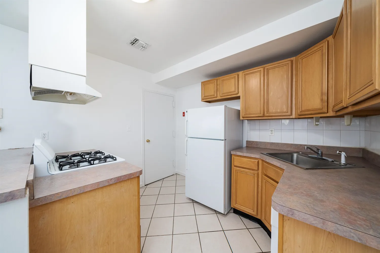 a kitchen with a sink a stove a refrigerator and cabinets